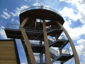 A multi-level observation tower with metal railings and wooden beams.