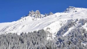 Een berg bedekt met sneeuw, met een helderblauwe lucht.