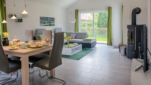 Un salon moderne comprenant un coin repas, un canapé, une cheminée et une vue sur l’extérieur.
