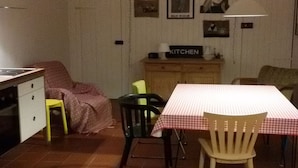 Une cuisine compacte comprenant une table à manger, des chaises et un petit meuble étiqueté « CUISINE ».