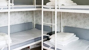 A bunk bed room with a red rug, patterned wallpaper, and a small black table. - 4 Star Holiday Home in Frillesas (Frillesas)