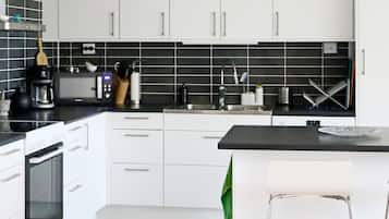 A modern kitchen with white cabinets, a black countertop, and a built-in oven.