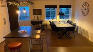 A modern kitchen with a central island, dining table, and bar stools. - 4 Star Holiday Home in Frillesas (Frillesas)
