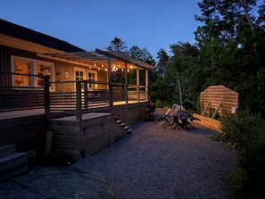 A wooden cabin with a covered porch, outdoor seating, and a gravel driveway. - 4 Star Holiday Home in Frillesas (Frillesas)