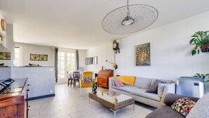 Un salon moderne comprenant un canapé, une table basse et un coin repas avec des chaises.