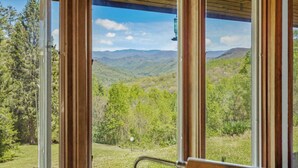 A room with a large window offering a view of a mountainous landscape. - GrandView @ Smoky Ridge: Stunning Mtn Views, Large Deck & Windows | Pet Friendly (Cullowhee)