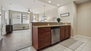 Cocina moderna con una isla central, electrodomésticos integrados y vista al área de estar.