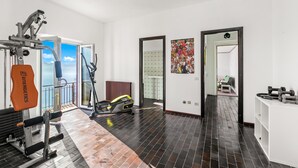 A gym with exercise equipment, a treadmill, and a view of the outdoors. - Lago Azzurro Villa: Infinity Lake View (Premeno)
