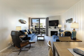 A living room with a sofa set, a coffee table, a TV, and a fireplace. - Relax & Unwind in a 2-Bedroom Oceanview Paradise (Oceanside)