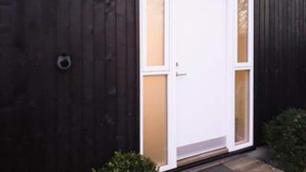 A white door with a glass panel, set in a dark wooden wall. - 4 Star Holiday Home in Gorlev (Gørlev)