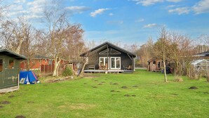 A residential property with a detached house featuring a porch, a fenced yard, and a greenhouse. - 4 Star Holiday Home in Gorlev (Gørlev)