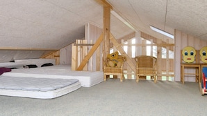 A loft bedroom with a sloped ceiling, wooden beams, a bed, two wicker chairs, and a teddy bear. - 4 Star Holiday Home in Gorlev (Gørlev)