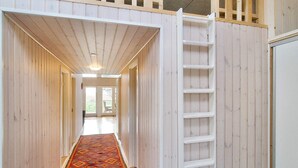A narrow hallway with a wooden floor and a patterned rug, leading to a door with a view of the outdoors. - 4 Star Holiday Home in Gorlev (Gørlev)