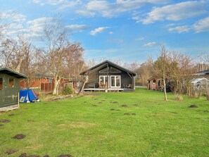 A residential property with a large lawn, a wooden deck, and a detached garage. - 4 Star Holiday Home in Gorlev (Gørlev)