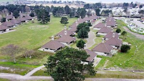 A residential area with multiple houses featuring pitched roofs and chimneys, surrounded by green lawns and trees. - 5 Person Holiday Home on a Holiday Park in Karrebaeksminde (Karrebæksminde)