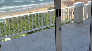 A balcony with a view of the ocean and beach. - Sunshine Modern Retreat (Port Alfred)