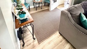 A cozy living room with a grey sofa, a coffee table with decorative items, a small side table, and a door leading to another room. - Home away from home, 
 By university , hospitals ,  museum,
Pet friendly. (Cleveland)