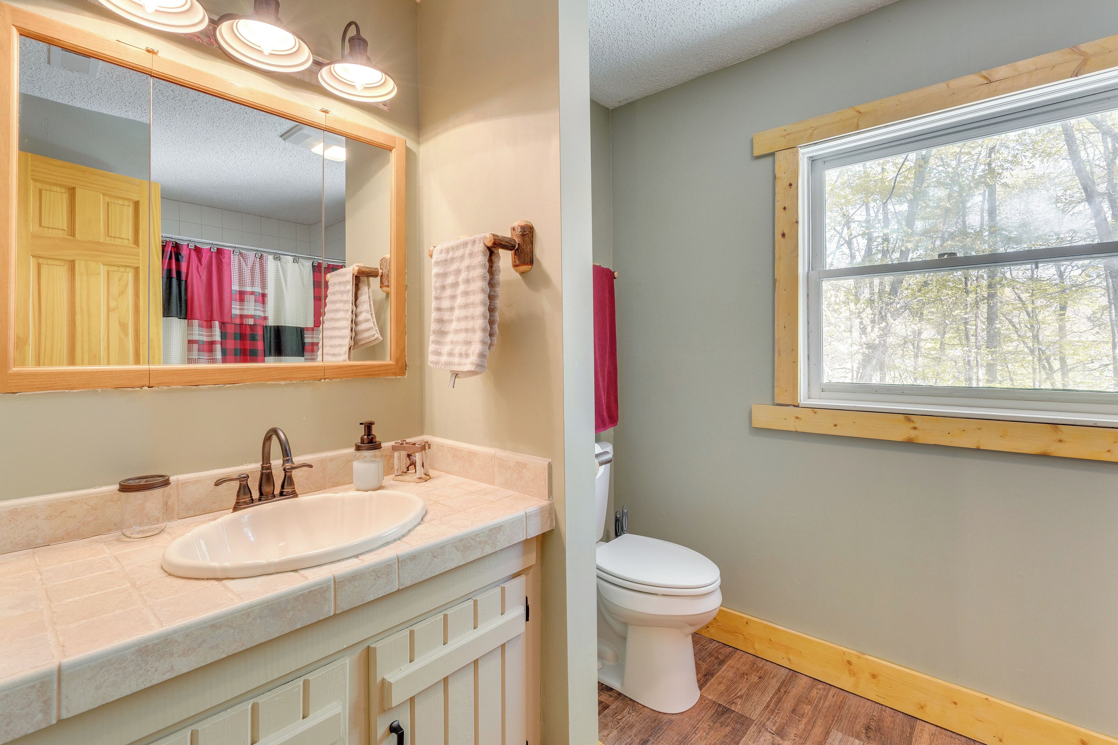 A bathroom with a sink, mirror, and toilet.