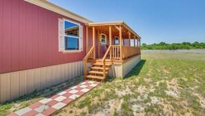 Ein eingeschossiges Haus mit einer Holzveranda und roter Außenfassade.