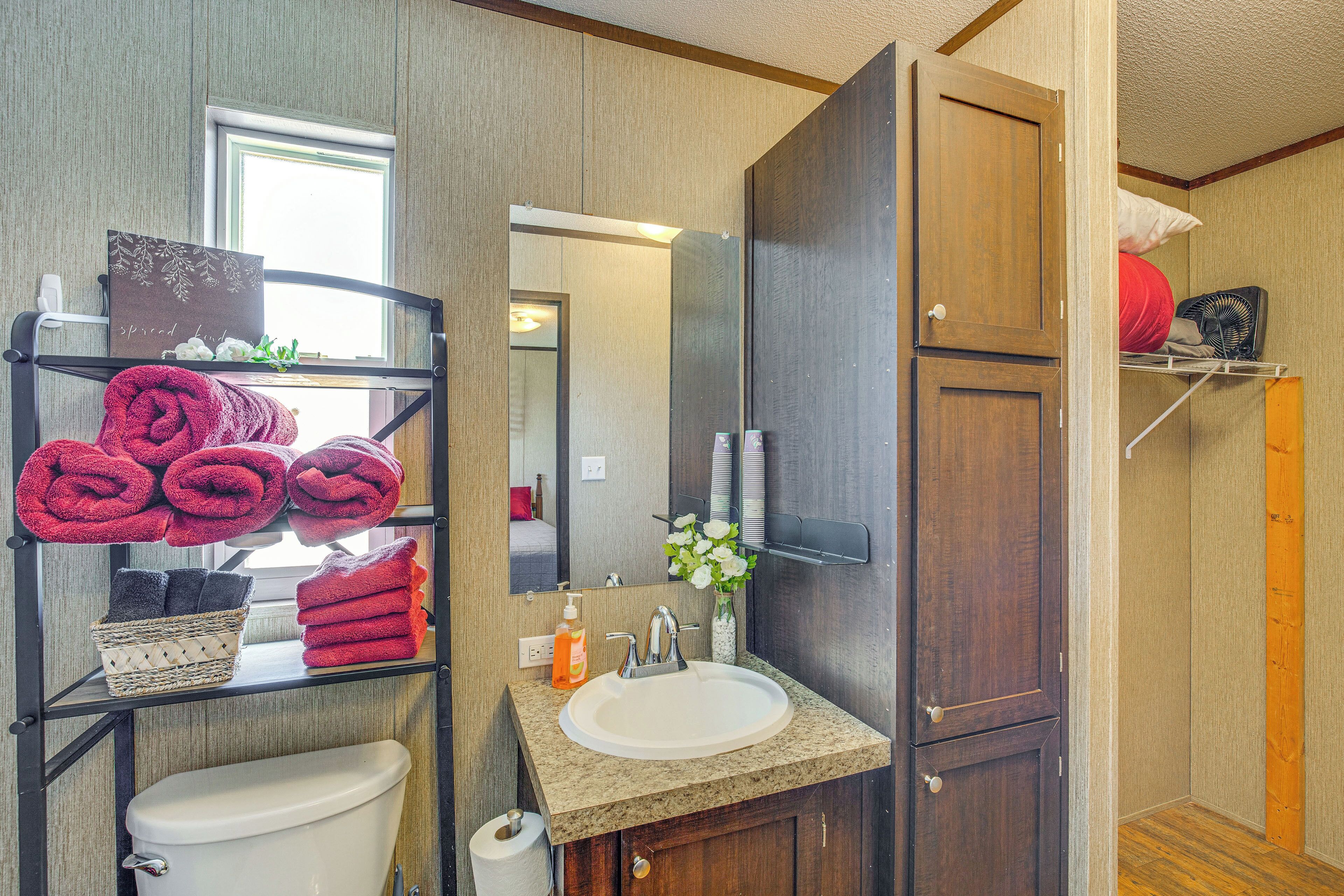 A bathroom with a toilet, sink, and towel rack.