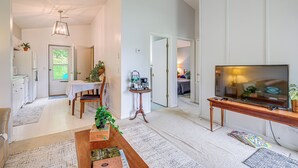 A spacious living area with a wooden coffee table, a television on a stand, and a dining area with a table and chairs. - Roanoke Mountain Home: 4 Mi to Blue Ridge Parkway! (Roanoke)