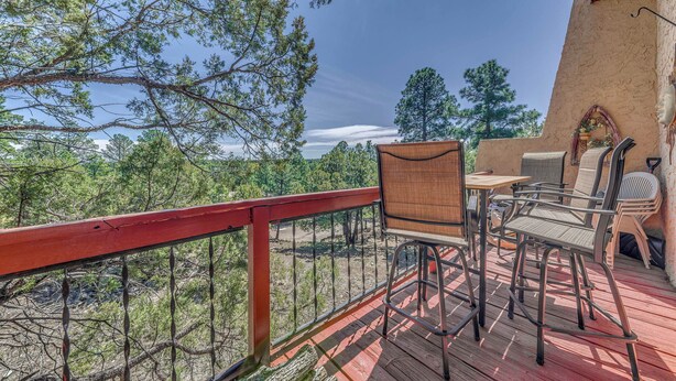 A wooden deck with outdoor furniture, a red railing, and a view of trees and sky. - Alto Townhome w/ Deck Near Ski Apache! (Alto)