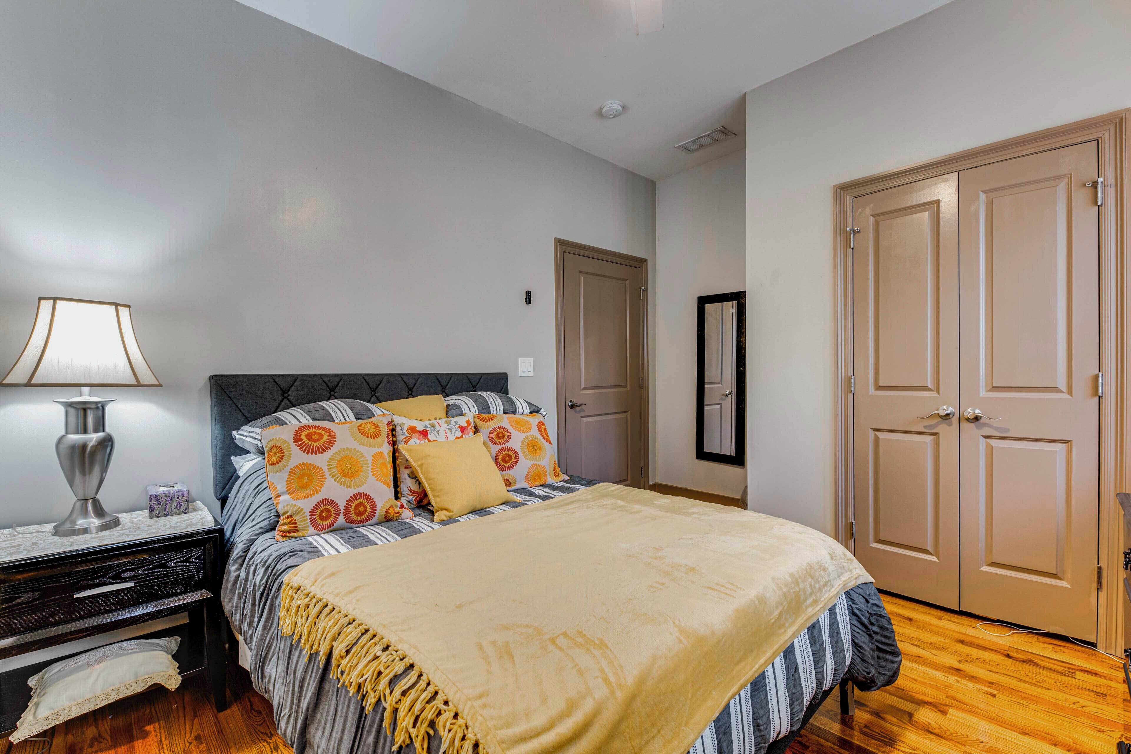 A bedroom with a bed, bedside table, lamp, and wardrobe.