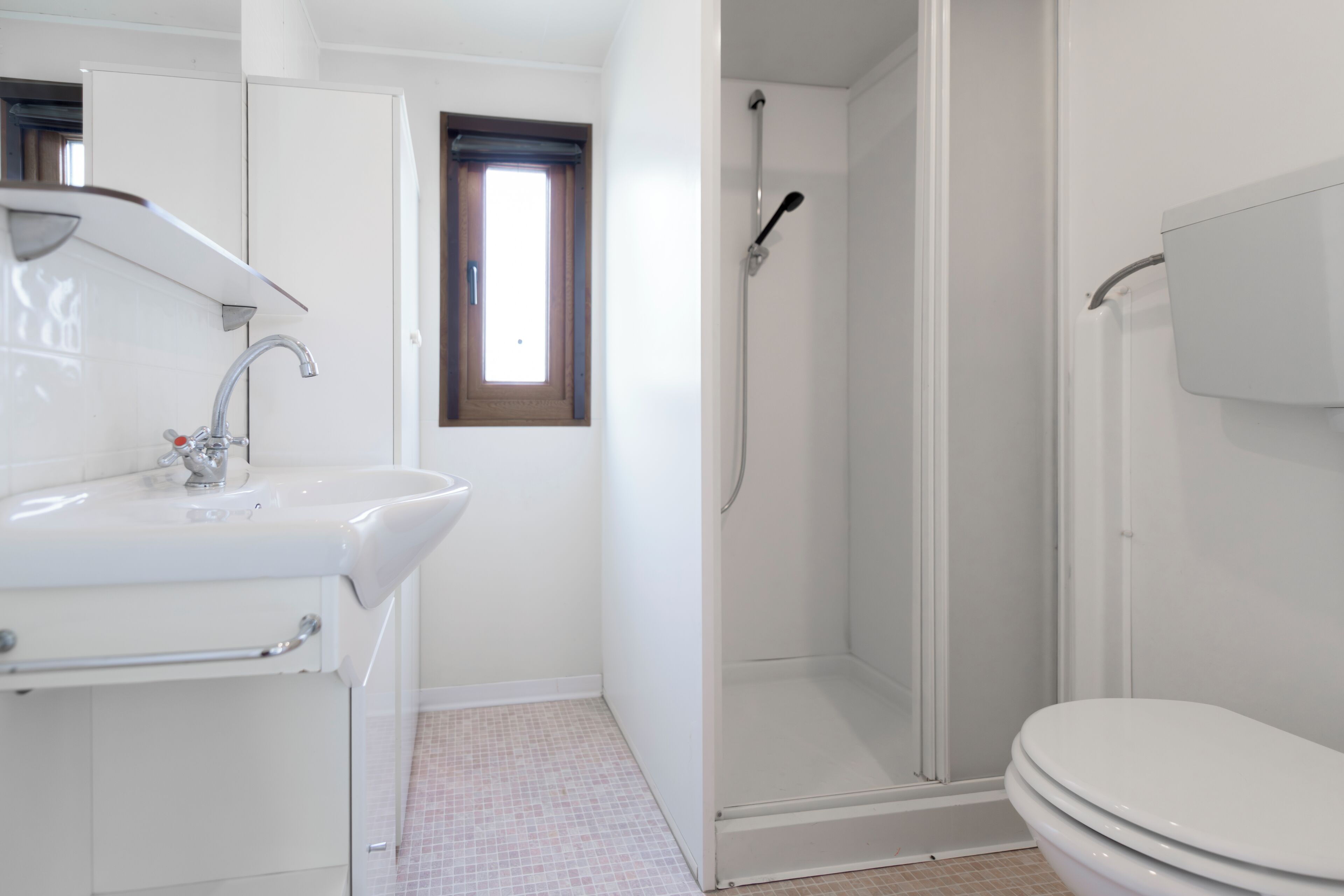 Un baño con lavamanos, inodoro y ducha.