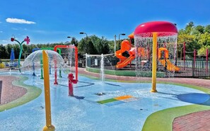 Un área de juegos acuáticos con múltiples chorros de agua y toboganes.