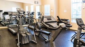 A gym with various cardio machines, weight benches, and dumbbells. - Villas at Seven Dwarfs 4BR, 3B, WiFi, 15min DW (Kissimmee)