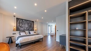 A modern bedroom with a large bed, a wall-mounted artwork, and a built-in shelving unit. - Villa Moderna con Encanto a 15 Minutos de Sevilla (Gelves)