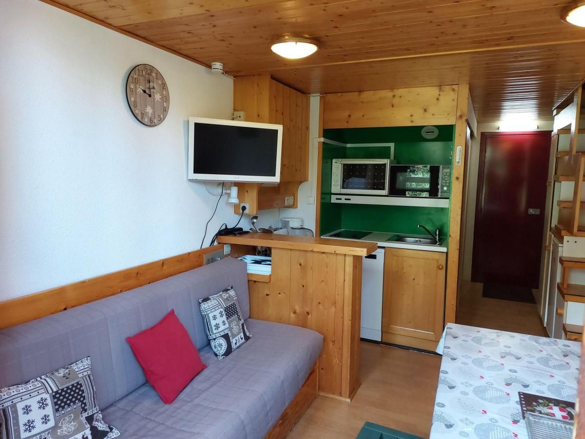 Ein gemütlicher Wohnbereich mit einer Couch, einem Flachbildfernseher, einer Küchenzeile und einer Mikrowelle.
