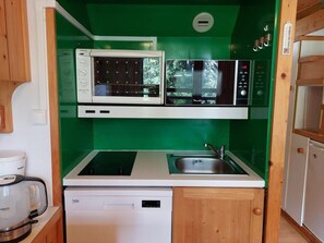 A compact kitchen with a microwave, a coffee maker, and a dishwasher.