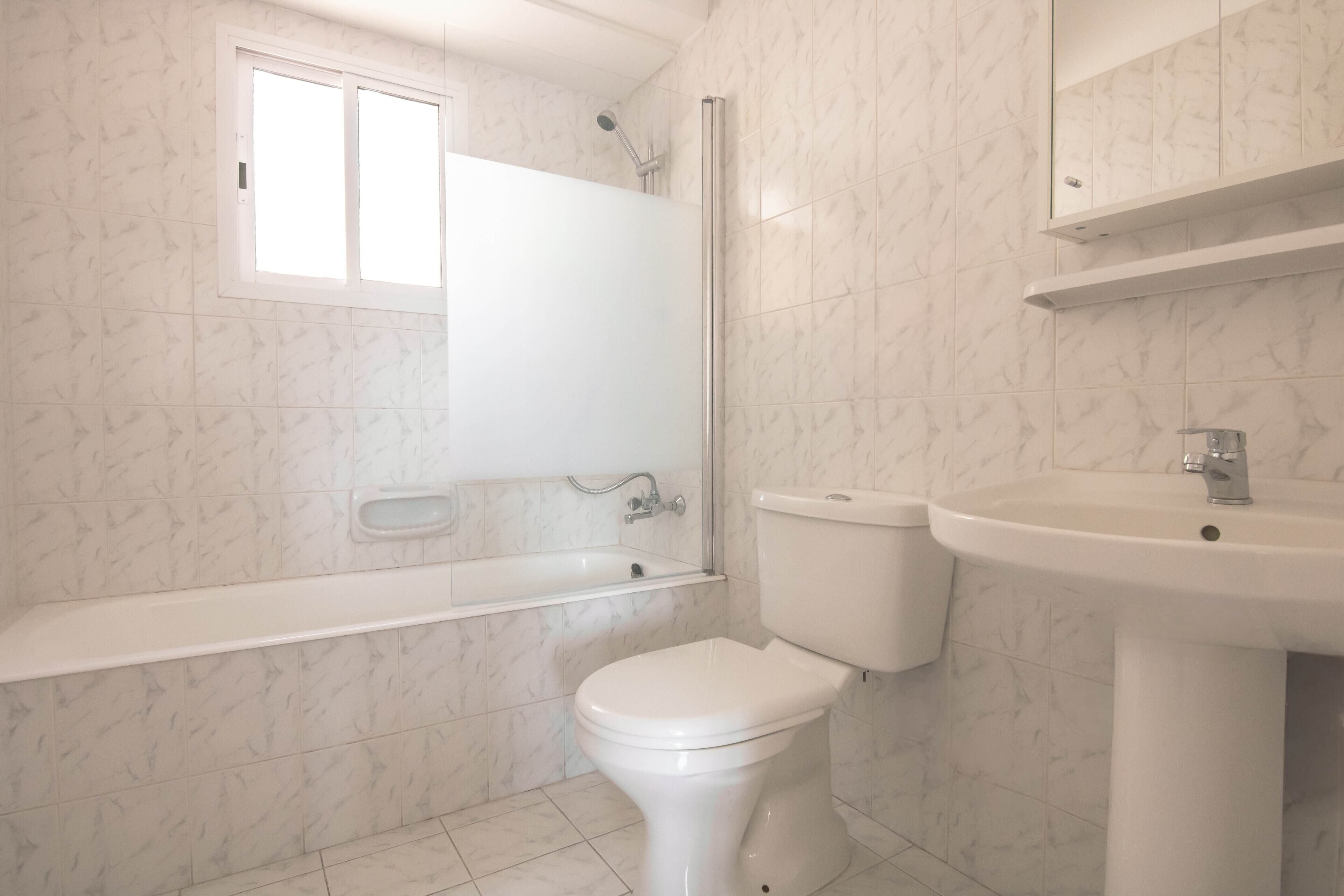 A bathroom with a toilet, sink, and bathtub.