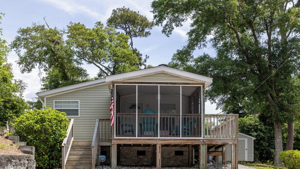 A two-story house with a covered porch and a small deck. - Poe's Paradise: Soundside 3 Bedrooms 2 Full Baths - close to beach (Emerald Isle)