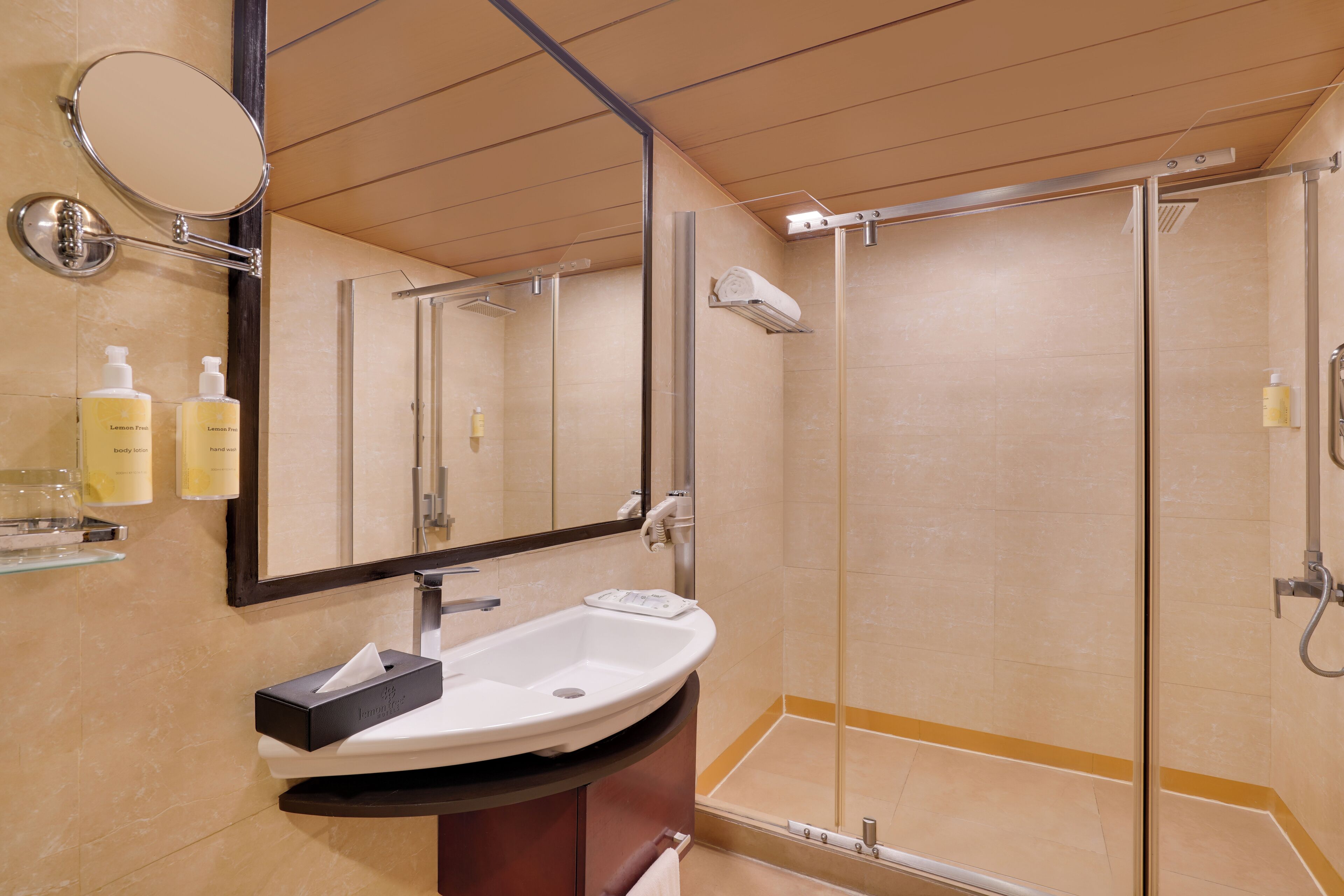 Un baño moderno con lavamanos, espejo y ducha.