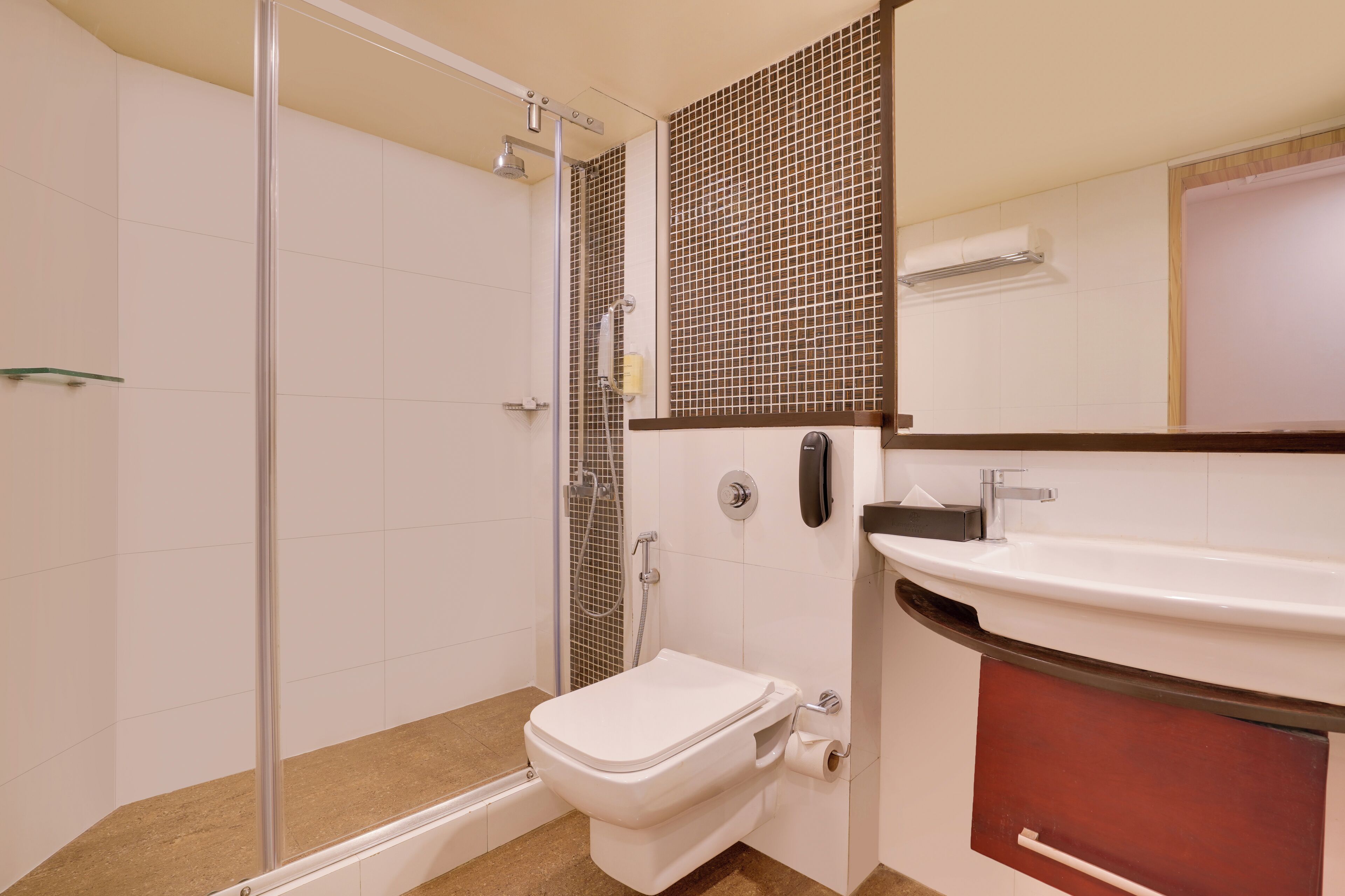 A bathroom with a shower, toilet, sink, and a mirror.