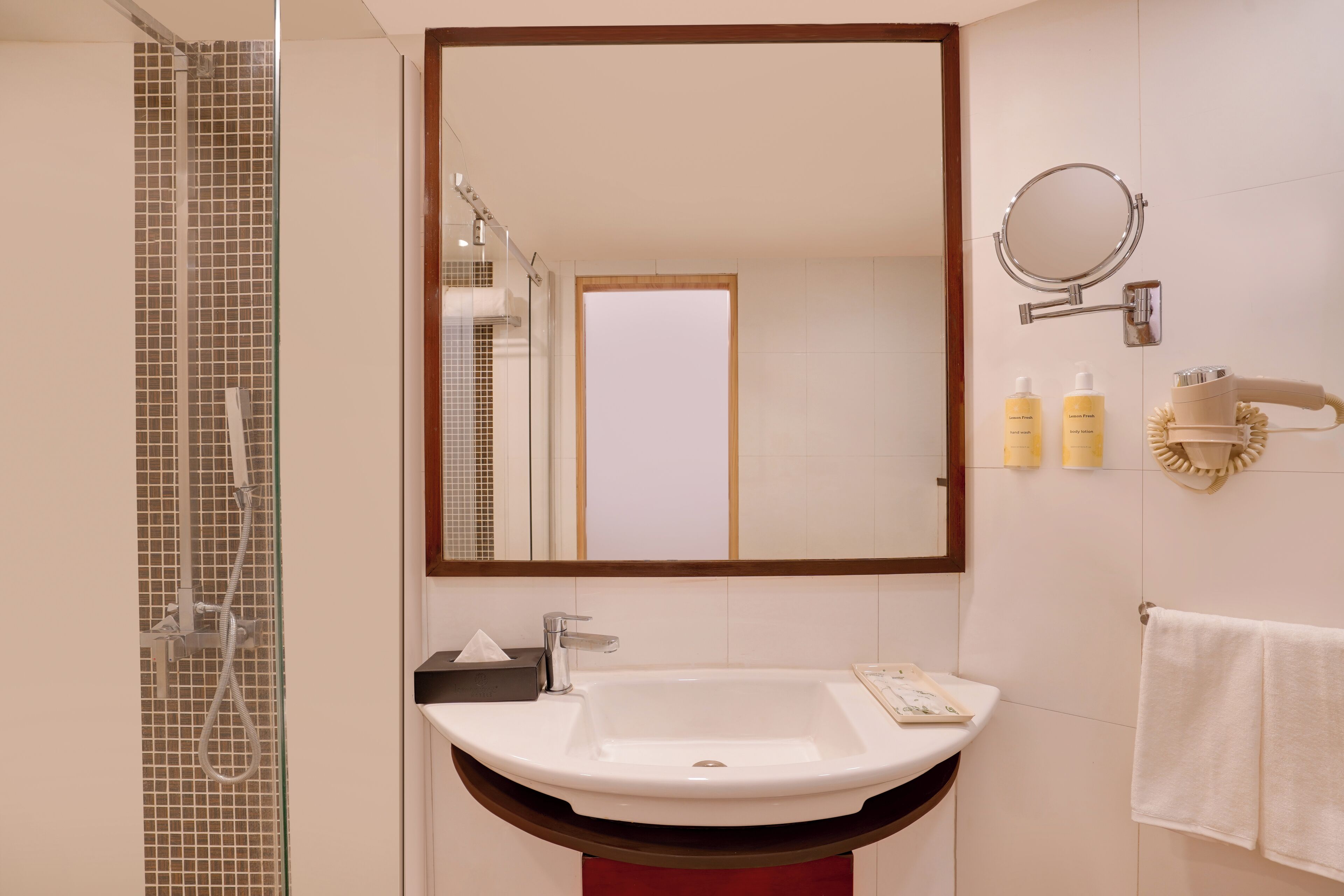 A bathroom with a sink, mirror, towel rack, and toiletries.