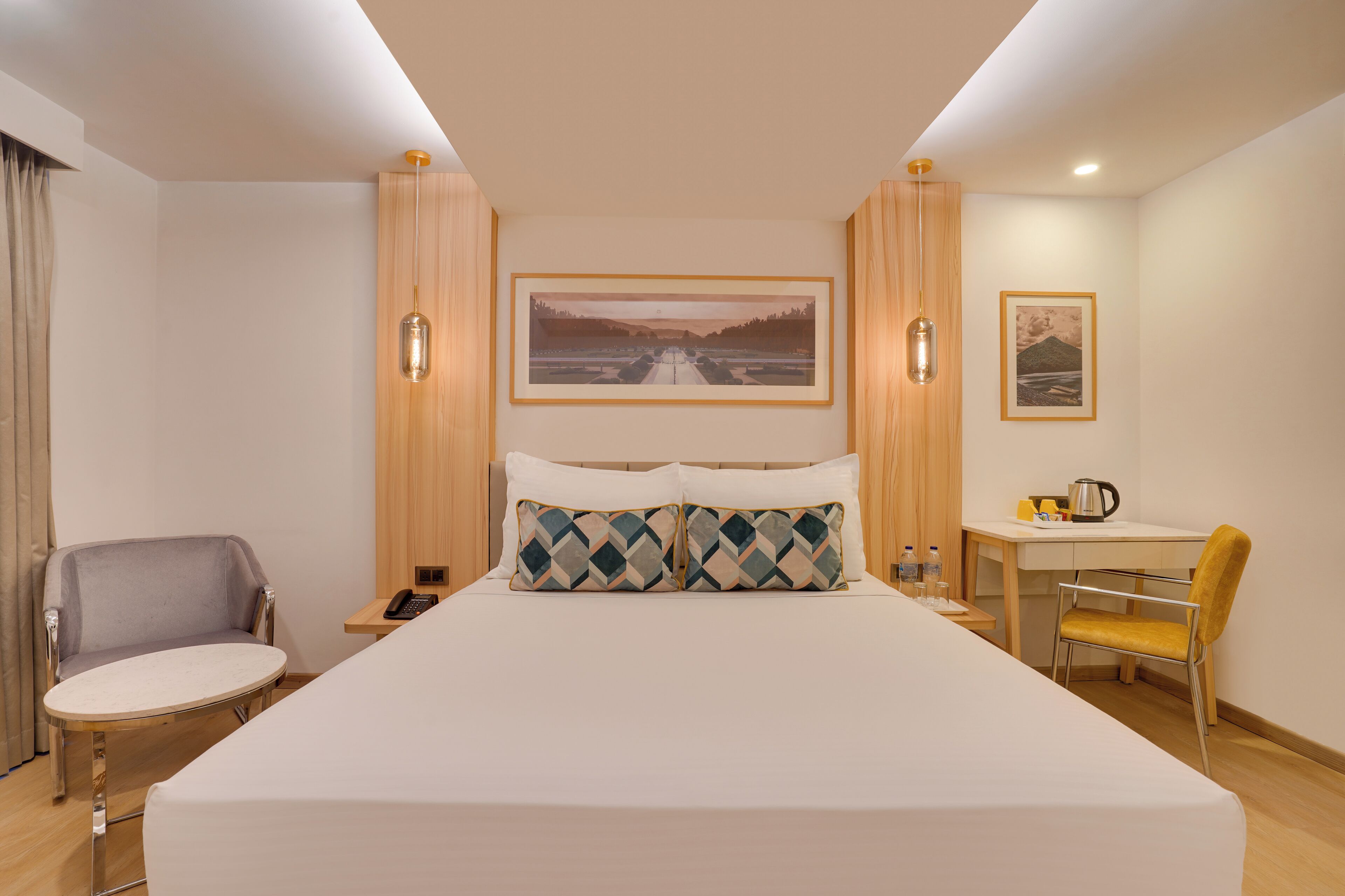 A hotel room with a bed, a desk, a chair, and a nightstand.