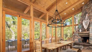 A wooden dining area with a large table, chairs, and a stone fireplace. - Historic Doodlebug Ranch - A Sedona Landmark (Sedona)