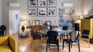 Un coin repas avec une table ronde, des chaises et des tableaux encadrés accrochés au mur.