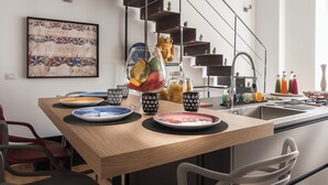 Une cuisine moderne avec un îlot central en bois, un escalier et un élément décoratif mural.