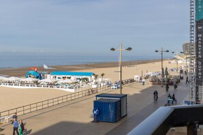 A beachside promenade with a blue building, a large inflatable structure, and a blue shipping container. - Charming Apartment With sea View (Middelkerke)