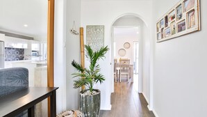 Un pasillo moderno con una planta en maceta, un banco de madera y una pared con citas motivacionales.
