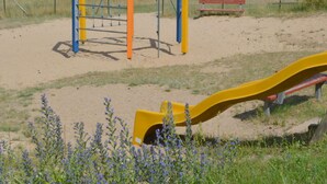 Un parque infantil con un tobogán amarillo y estructuras para escalar.