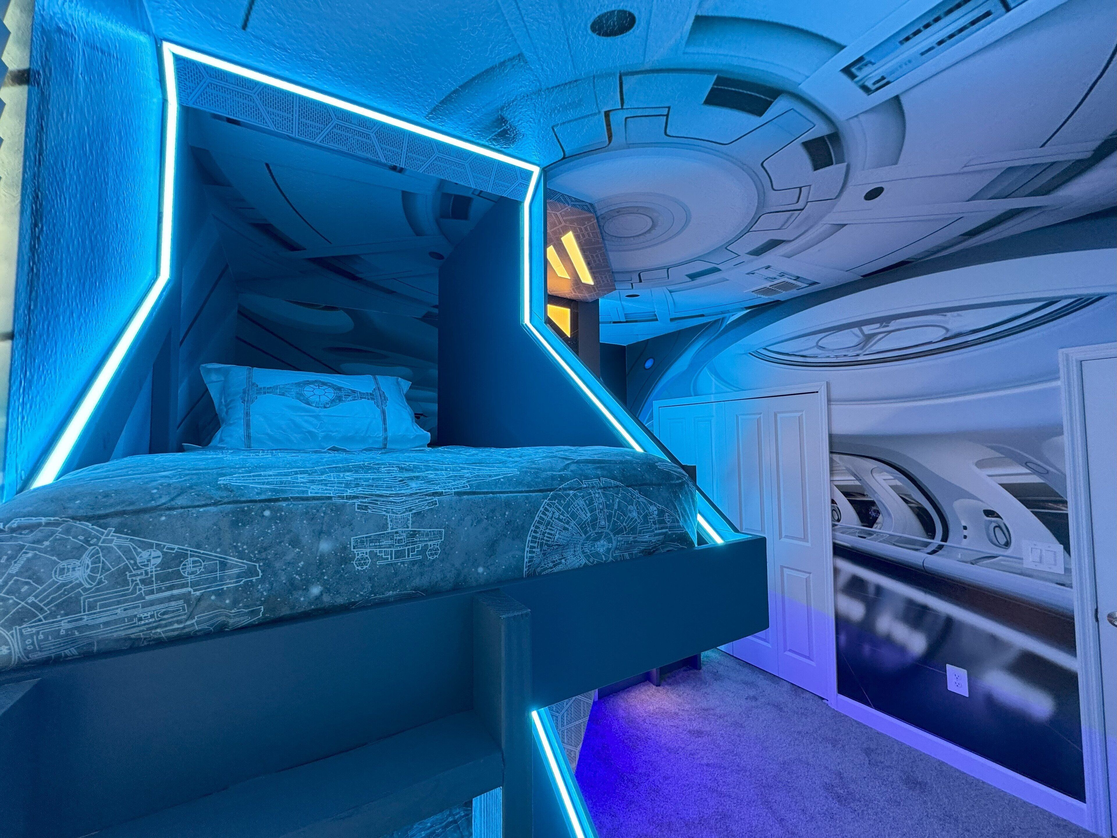 Ein futuristisches Schlafzimmer mit Etagenbett, geometrischen Mustern an den Wänden und einem modernen Deckenbau.