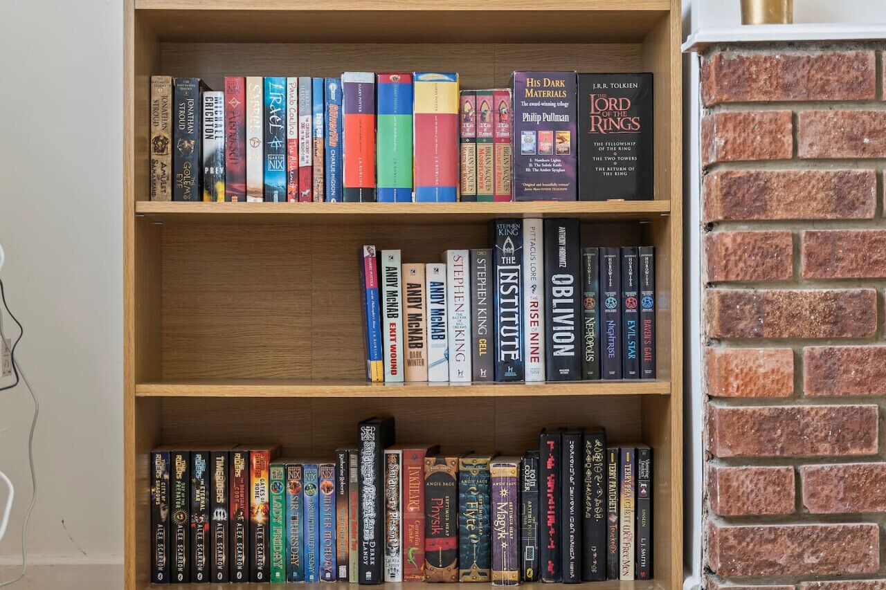 Ein Bücherregal mit verschiedenen Büchern, darunter Titel wie 'Der Herr der Ringe' und 'Oblivion'.