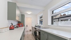 Cocina moderna con lavadora integrada, un ventanal amplio y vistas al vecindario.