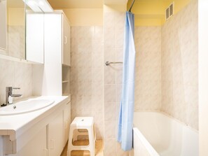 A bathroom with a bathtub, a shower curtain, a toilet, and a sink. - Apartment Near Belgian Coast With Sea View (Koksijde)