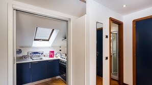 A compact kitchen with a skylight, a built-in oven, and a sink.